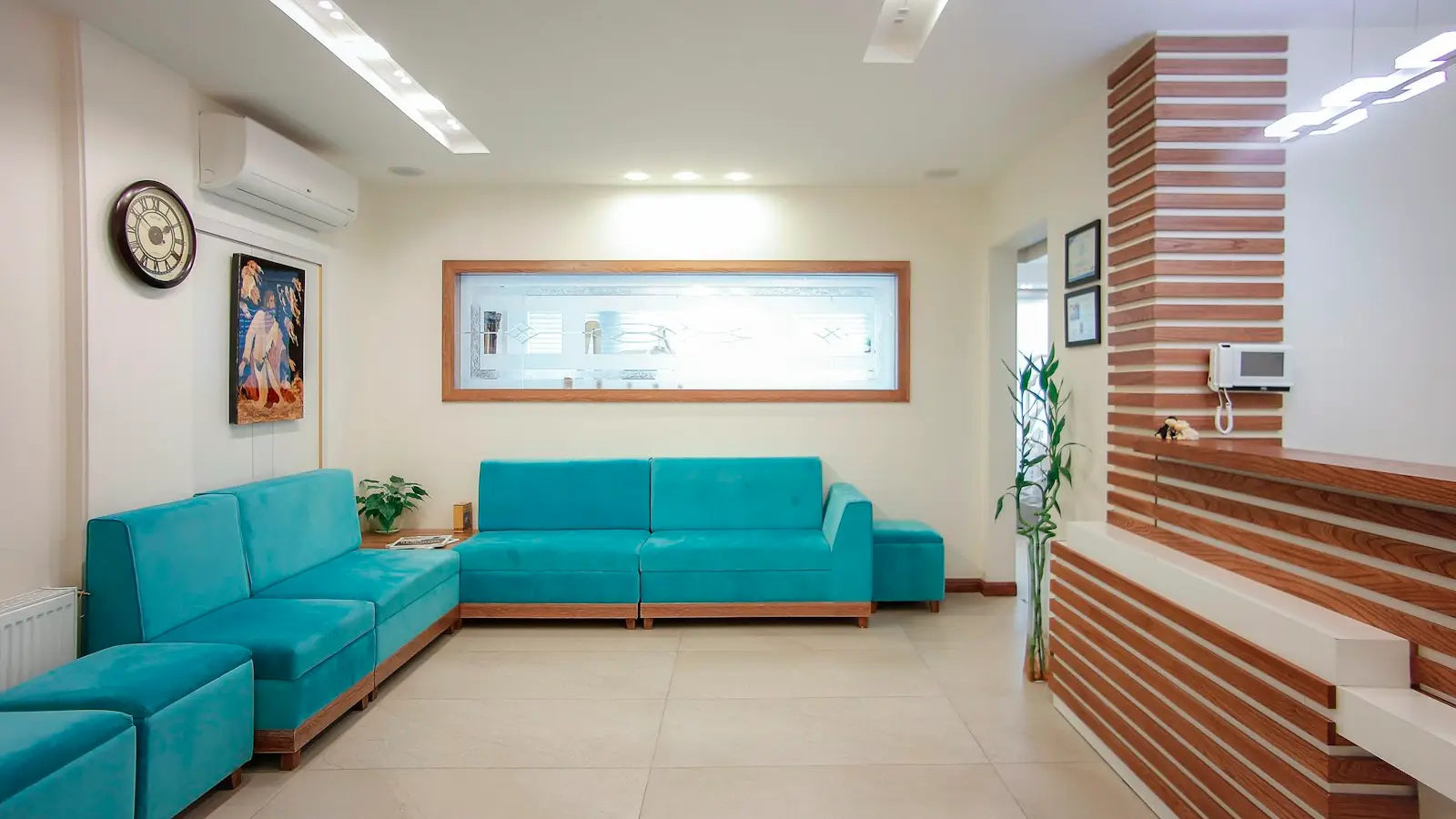 A bright dental office waiting room with blue couches